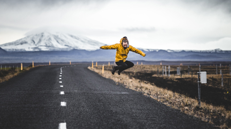 Man in Rainydays jacket with snowy mountain behind him